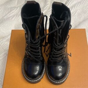 Louis Vuitton Star Trail ankle boots crafted from black patent leather.